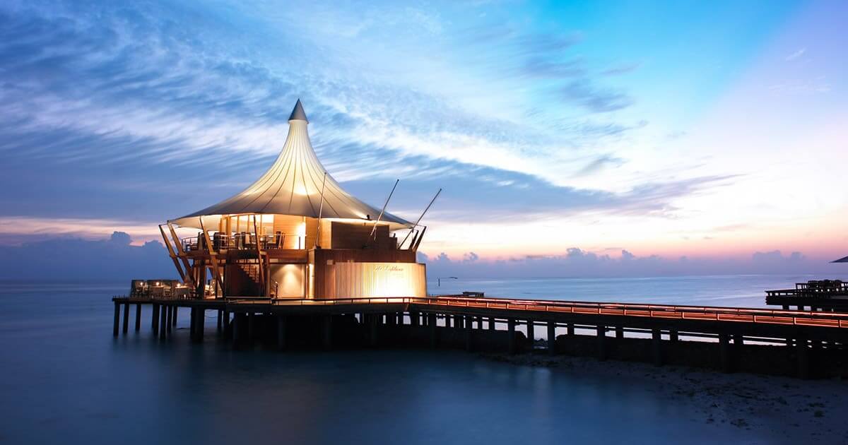 overwater restaurant illuminated at night in Baros, Maldives